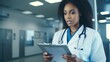 © vefimov - A woman doctor is looking at a clipboard in a hospital. She is wearing a white coat and has a stethoscope around her neck