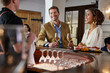 © Trinette Reed/Stocksy - Couple wine tasting at winery talking to bartender