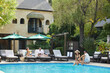 © Trinette Reed/Stocksy - Couples talking by pool at luxury hotel vacation