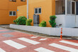 © Jeongho Byeon/Stocksy - Crosswalk on the street and yellow buildings and trees behind it.