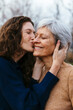 © BONNINSTUDIO/Stocksy - Adult daughter kissing her mother