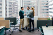 © VICTOR TORRES/Stocksy - Casual business discussion in a modern office setting