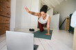 © Nicola Suttle/Stocksy - Woman practicing online yoga in Balancing Table pose