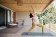 © Nicola Suttle/Stocksy - Slim woman doing Reverse Warrior yoga in pose