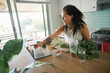 © Nicola Suttle/Stocksy - Cheerful woman cooking in kitchen and watching tutorial