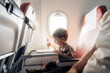 © Santi Nuñez/Stocksy - boy drawing during flight in plane