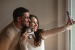 © Alina Hvostikova/Stocksy - Cheerful couple taking selfie with ultrasound image