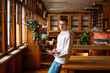 © Studio Firma/Stocksy - Teenager posing in library
