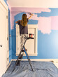 © Raymond Forbes LLC/Stocksy - Young girl Painting her colorful bedroom  renovation of room in house