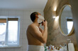 © Olga Murzaeva/Stocksy - a young man shaves with a razor in the bath