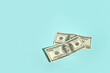 © Tatyana Lavrova/Stocksy - Two hundred-dollar bills on a cyan blue background with copy space