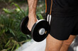 © VICTOR TORRES/Stocksy - Man holding dumbbell outdoors for fitness exercise