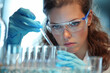 a Caucasian female scientist working with a test tube in the laboratory.