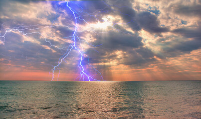 Wall Mural - Beautiful landscape with lightning over the calm sea at sunset 