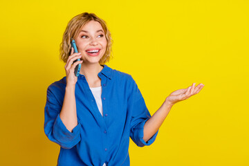 Canvas Print - Portrait of pretty young lady speak phone wear blue shirt isolated on yellow color background