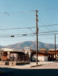 © Anna Dave/Stocksy - Western small town in Colorado with mountains, signs electric poles.