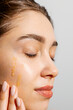 © Artem Podrez/Stocksy - A Woman Applying Facial  lotion Skincare Routine