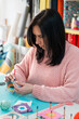 © nomad studio/Stocksy - Craftswoman focused on crocheting colorful yarn