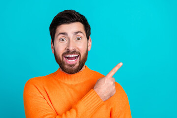 Poster - Photo of cheerful glad nice man wear orange trendy clothes demonstrate empty space isolated on cyan color background