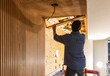 © Raymond Forbes LLC/Stocksy - Blue Collar worker Carpenter building Vertical wood paneling home