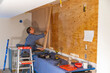 © Raymond Forbes LLC/Stocksy - Home Construction worker building Vertical wood wall