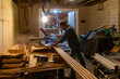 © Raymond Forbes LLC/Stocksy - Construction Carpenter cutting wood with saw at night home rernovation