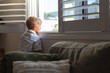 © Jodie Johnson Photography/Stocksy - Young boy looking longingly out a window