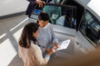 © Jovo Jovanovic/Stocksy - Customer and car salesperson pointing at details of the contract