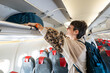 © Alvaro Lavin/Stocksy - Placing the hand luggage in overhead bin.