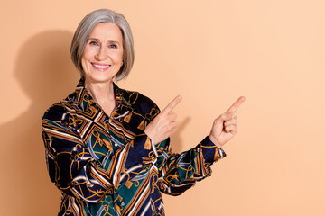 Poster - Photo of pleasant clever person with gray hairdo wear print blouse indicating at sale empty space isolated on beige color background