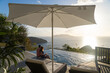 © JP Danko/Stocksy - Couple Sitting by Pool With Cocktails and Ocean View at Caribbea