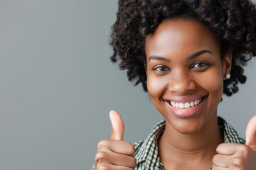 Closeup of a cheerful young woman with curly hair giving a double thumbs up