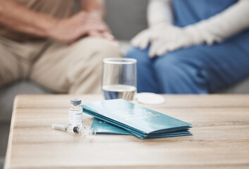 Wall Mural - Nurse, pamphlet and covid vaccine on table in home for health education or awareness in living room. People, brochure and vial syringe for medicine, wellness and virus with healthcare pharmacy drugs