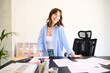 © Guille Faingold/Stocksy - Cheerful Businesswoman at Desk with Documents