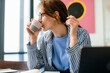 © DZ FILM/Stocksy - A woman drinks coffee working at home