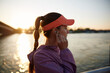 © Boris Jovanovic/Stocksy - Sportswoman adjusts her headset by the river