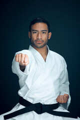 Wall Mural - Karate, master and portrait of man in martial arts on studio, black background or practice exercise. Serious, fight and person with self defence skill, technique or fighter gesture action with hands