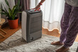 © Lupe Rodríguez/Stocksy - turning on air purifier at home