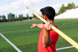 Fototapeta Zachód słońca - An athletic man throws the javelin in the stadium.