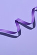 © Marc Tran/Stocksy - Purple curly ribbon isolated on purple background.