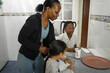 © Lupe Rodríguez/Stocksy - black mother with daughters having breakfast in kitchen at home