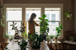 © Gabi Bucataru/Stocksy - Woman cleaning indoors plants