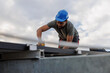 © Jovo Jovanovic/Stocksy - Technician installing solar panels on rooftop