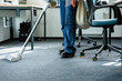 © DZ FILM/Stocksy - A woman vacuums in the office after a celebration