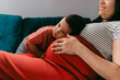 © Lea Jones/Stocksy - pregnant  mother cuddling toddler on the couch