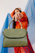 © Tania Cervian/Stocksy - Model in fishnet outfit displaying handbag while standing in studio
