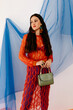 © Tania Cervian/Stocksy - Fashionable model in fishnet outfit standing in studio with purse