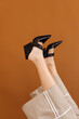 © Tania Cervian/Stocksy - Crop female in stylish black heels sandal against brown background