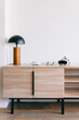 © VICTOR TORRES/Stocksy - Modern sideboard with table lamp and VR headsets