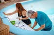 © A2 Images/Stocksy - Father and daughter washing a pool